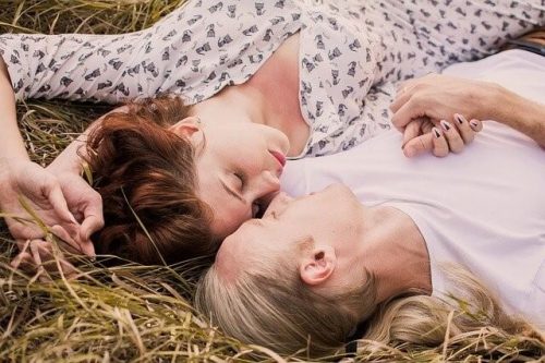 草原に寝転がるカップル