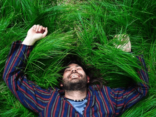 草原で寝転ぶ男性